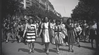 Jeunes femmes défilant dans les rues de Paris vêtues de robes aux couleurs des Alliés pour célébrer la Victoire